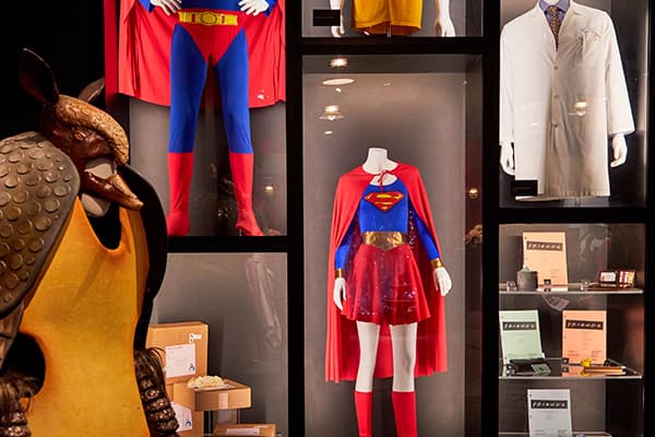 Mannequins with Superman and Supergirl costumes, armadillo suit, and a white lab coat display.